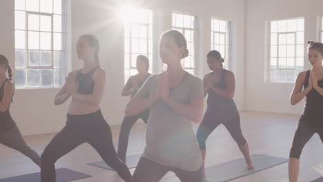 yoga-class-of-young-pregnant-women-practicing-prayer-pose-enjoying-healthy-lifestyle-group-fitness-workout-in-exercise-studio-at-sunrise