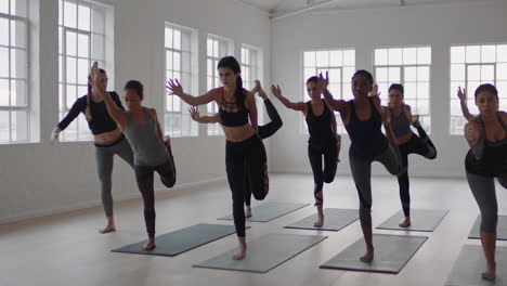 Yoga-Kursgruppe-Gemischtrassiger-Frauen,-Die-Die-Pose-„Herr-Des-Tanzes“-Praktizieren-Und-Einen-Gesunden-Lebensstil-Genießen,-Indem-Sie-Im-Fitnessstudio-Trainieren-Und-Gruppenmeditation-Bei-Sonnenaufgang-Unterrichten