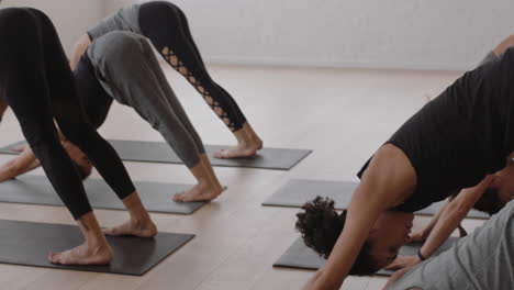 Schöne-Yoga-Lehrerin-Unterrichtet-Krieger-Pose-Meditation-Mit-Einer-Gruppe-Gemischtrassiger-Frauen,-Die-Einen-Gesunden-Lebensstil-Genießen-Und-Im-Fitnessstudio-Trainieren