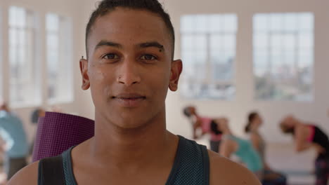 yoga-class-portrait-of-attractive-mixed-race-man-smiling-confidently-enjoying-healthy-lifestyle-with-multi-ethnic-people-practicing-in-fitness-studio-background