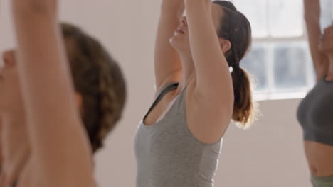 Yoga-Klasse,-Gesunde-Kaukasische-Frau,-Die-Kriegerpose-Praktiziert-Und-Den-Fitness-Lebensstil-Genießt-Und-Mit-Multiethnischen-Menschen-Im-Trainingsstudio-Trainiert