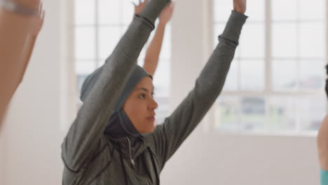 Yoga-Kurs:-Junge-Muslimische-Frau-Praktiziert-Kriegerpose-Und-Genießt-Einen-Gesunden-Lebensstil-Beim-Training-Mit-Multiethnischen-Menschen-Im-Fitnessstudio