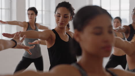 beautiful-yoga-woman-instructor-teaching-reverse-warrior-pose-meditation-with-group-of-multiracial-women-enjoying-healthy-lifestyle-exercising-in-fitness-studio-at-sunrise