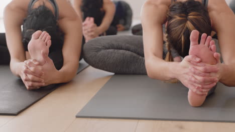 Eine-Gruppe-Junger-Frauen-Im-Yoga-Kurs-übt-Die-Pose-Von-Kopf-Bis-Knie-Nach-Vorne-Und-Genießt-Einen-Gesunden-Lebensstil,-Indem-Sie-In-Der-Meditation-Im-Fitnessstudio-Trainieren