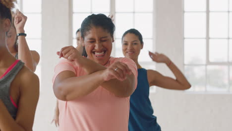 Glückliche-übergewichtige-Frau-Tanzt-Gruppe-Gesunder-Menschen,-Die-Das-Training-Genießen-Und-Choreografie-Tanzbewegungen-üben-Und-Spaß-Im-Fitnessstudio-Haben