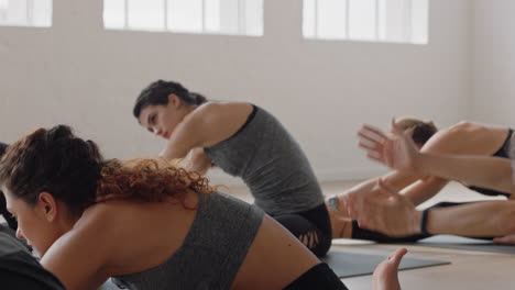 Gesunde-Yoga-Frau-übt-Sitzende-Seitenbeuge-Pose.-Junge-Kaukasische-Frau-Genießt-Den-Fitness-Lebensstil-Und-Trainiert-Im-Studio-Mit-Einer-Gruppe-Gemischtrassiger-Frauen