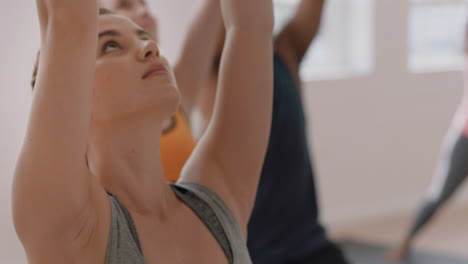 Yoga-Klasse,-Gesunde-Kaukasische-Frau,-Die-Kriegerpose-Praktiziert-Und-Den-Fitness-Lebensstil-Genießt-Und-Mit-Multiethnischen-Menschen-Im-Trainingsstudio-Trainiert