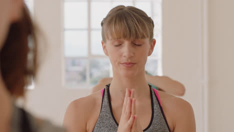 Clase-De-Yoga-Mujer-Caucásica-Saludable-Practicando-Pose-Guerrera-Disfrutando-De-Un-Estilo-De-Vida-Físico-Haciendo-Ejercicio-Con-Personas-Multiétnicas-En-Un-Estudio-De-Entrenamiento