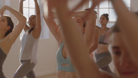 Yoga-Kurs:-Gesunde-Kaukasische-Frau-übt-Kriegerpose-Mit-Einer-Gruppe-Schöner-Frauen,-Die-Einen-Gesunden-Lebensstil-Genießen-Und-Bei-Sonnenaufgang-Im-Fitnessstudio-Trainieren