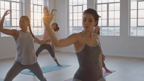 yoga-class-of-beautiful-women-practice-reverse-warrior-pose-enjoying-healthy-lifestyle-exercising-in-fitness-studio-instructor-guiding-group-meditation-teaching-workout-posture-at-sunrise
