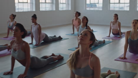 Yoga-Kurs-Mit-Gesunden-Frauen,-Die-Die-Kobra-Pose-Praktizieren-Und-Das-Training-Im-Fitnessstudio-Genießen.-Lehrer,-Der-Gruppenmeditation-Leitet-Und-Trainingshaltung-Bei-Sonnenaufgang-Lehrt
