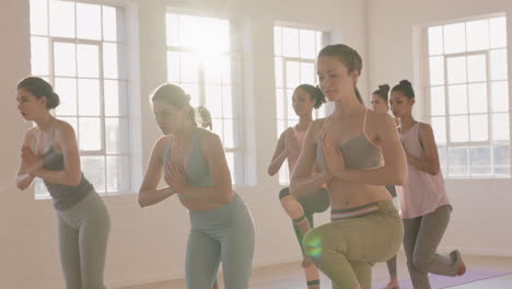 Yoga-Klasse,-Multiethnische-Frauen,-Die-Kriegerpose-Praktizieren-Und-Einen-Gesunden-Lebensstil-Genießen-Und-Bei-Sonnenaufgang-Im-Fitnessstudio-Trainieren
