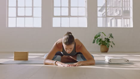 Gesunde-Yoga-Frau-übt-Eine-Einfache-Pose-Nach-Vorne,-Genießt-Den-Fitness-Lebensstil-Und-Trainiert-Im-Studio,-Indem-Sie-Bei-Sonnenaufgang-Ein-Schönes-Körpertraining-Auf-Einer-Trainingsmatte-Ausdehnt
