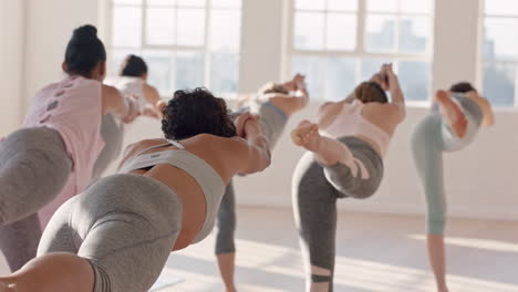 Clase-De-Yoga-De-Hermosas-Mujeres-Practicando-Pose-Guerrera-Estirando-El-Cuerpo-Disfrutando-De-Un-Estilo-De-Vida-Saludable-Haciendo-Ejercicio-En-El-Gimnasio-Al-Amanecer
