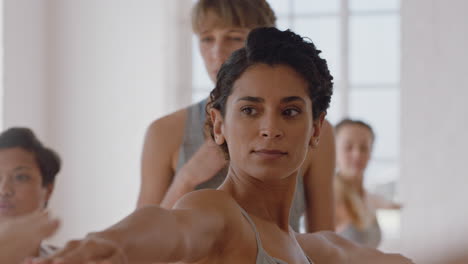 Yoga-Klasse,-Schöne-Hispanische-Frau,-Die-Kriegerpose-Praktiziert,-Fitnesstrainerin,-Die-Eine-Gruppe-Multiethnischer-Frauen-Unterrichtet,-Gesunde-Meditationspraxis-Im-Trainingsstudio