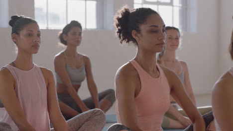 Yoga-Kurs:-Gesunde-Frau-Mit-Gemischter-Abstammung-übt-Gebetshaltung-Mit-Einer-Gruppe-Schöner-Frauen,-Die-Auf-Einer-Trainingsmatte-Sitzen-Und-Bei-Sonnenaufgang-Ein-Training-Für-Einen-Gesunden-Lebensstil-Im-Fitnessstudio-Genießen