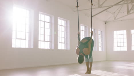 aerial-yoga-woman-practicing-standing-prayer-pose-using-hammock-enjoying-healthy-fitness-lifestyle-exercising-in-studio-training-meditation-at-sunrise