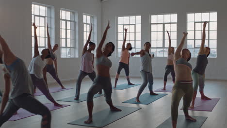 yoga-class-of-healthy-women-practicing-reverse-warrior-pose-enjoying-exercising-in-fitness-studio-instructor-leading-group-meditation-teaching-workout-posture-at-sunrise