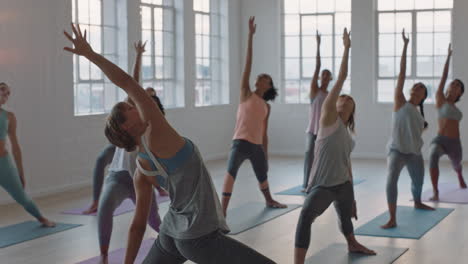 Yoga-Kurslehrerin,-Die-Gruppenmeditation-Leitet-Und-Gesunde-Frauen-In-Kriegerpose-Unterrichtet-Und-Das-Training-Im-Fitnessstudio-Genießt-Und-Die-Körperhaltung-Bei-Sonnenaufgang-übt