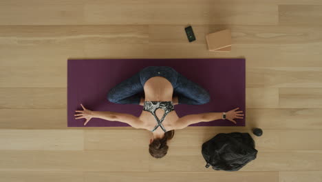 overhead-view-flexible-yoga-woman-practicing-stretching-body-enjoying-healthy-lifestyle-exercising-in-fitness-studio-training-on-exercise-mat