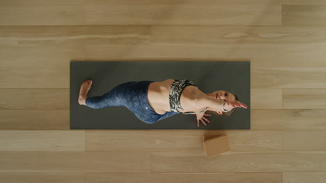 above-view-yoga-woman-practicing-extended-side-angle-pose-in-workout-studio-enjoying-healthy-lifestyle-meditation-practice-training-on-exercise-mat