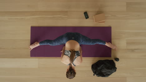 Ansicht-Von-Oben:-Flexible-Yoga-Frau-übt-Weitwinklig-Sitzende-Seitenbeuge-Pose-Und-Genießt-Einen-Gesunden-Lebensstil-Beim-Training-Im-Fitnessstudio-Auf-Einer-Trainingsmatte