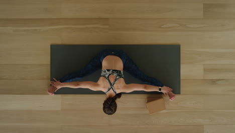 above-view-yoga-woman-practicing-seated-forward-bend-pose-in-workout-studio-enjoying-healthy-lifestyle-meditation-practice-training-on-exercise-mat