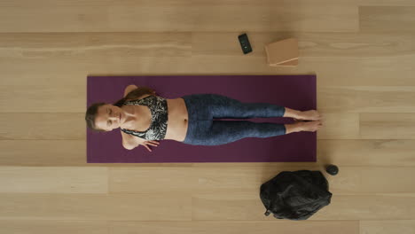 Vista-Aérea-Mujer-De-Yoga-Flexible-Practicando-Pose-De-Tabla-Hacia-Arriba-Disfrutando-De-Un-Estilo-De-Vida-Saludable-Haciendo-Ejercicio-En-El-Gimnasio-Entrenando-En-Una-Colchoneta-De-Ejercicios