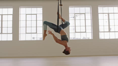 aerial-yoga-woman-practicing-bound-one-legged-king-pigeon-pose-hanging-upside-down-using-hammock-enjoying-healthy-fitness-lifestyle-exercising-in-studio-training-meditation-at-sunrise