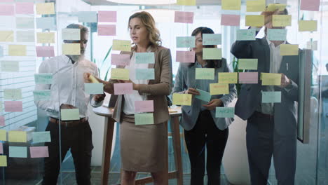 group-of-business-people-meeting-using-sticky-notes-brainstorming-colleagues-working-on-problem-solving-strategy-thinking-of-solution-for-project-in-corporate-office-4k