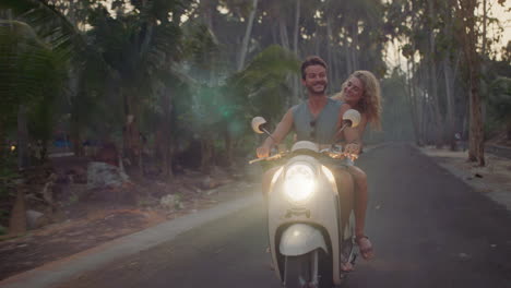 Glückliches-Paar,-Das-Bei-Sonnenaufgang-Auf-Einer-Tropischen-Insel-Einen-Roller-Fährt-Und-Eine-Romantische-Fahrt-Mit-Dem-Motorrad-Genießt,-Um-Wunderschöne-Reiseziele-Zu-Erkunden