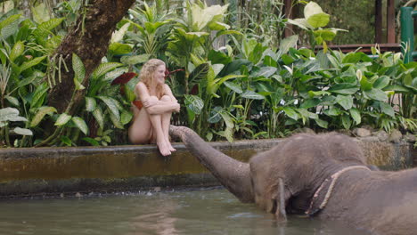 Mujer-Jugando-Con-Elefante-En-El-Zoológico-Rociando-Agua-Divirtiéndose-En-Vacaciones-Exóticas-En-Un-Santuario-De-Bosque-Tropical