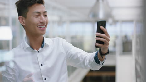 young-asian-businessman-having-video-chat-using-smartphone-chatting-on-mobile-phone-salesman-enjoying-conversation-with-client-in-corporate-office-workplace-4k