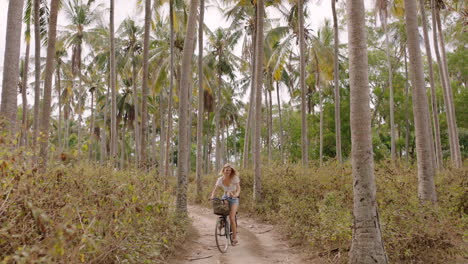 Mujer-Montando-Bicicleta-Explorando-Una-Isla-Tropical-Chica-En-Bicicleta-Disfrutando-Del-Hermoso-Bosque-De-Palmeras-4k