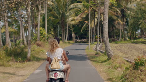 Touristenpaar-Fährt-Motorrad-Auf-Einer-Tropischen-Insel.-Glückliche-Frau-Feiert-Die-Freiheit-Mit-Erhobenen-Armen-Und-Genießt-Einen-Urlaubs-Roadtrip-Mit-Ihrem-Freund-Auf-Einer-Motorradfahrt.-Rückansicht
