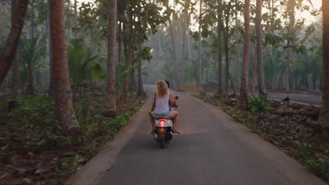 Glückliches-Paar,-Das-Bei-Sonnenaufgang-Auf-Einer-Tropischen-Insel-Einen-Roller-Fährt-Und-Eine-Romantische-Fahrt-Mit-Dem-Motorrad-Genießt,-Um-Wunderschöne-Reiseziele-Zu-Erkunden
