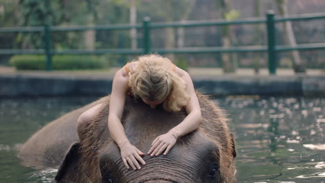 Hermosa-Mujer-Montando-Elefante-En-El-Zoológico-Jugando-En-La-Piscina-Salpicando-Agua-Turista-Divirtiéndose-En-Vacaciones-Exóticas-En-El-Santuario-Del-Bosque-Tropical