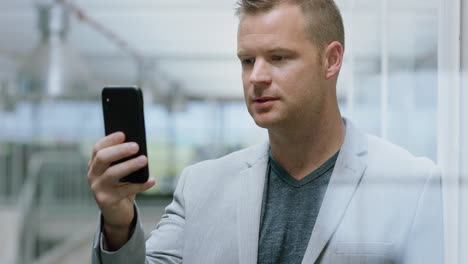 businessman-having-video-chat-using-smartphone-chatting-on-mobile-phone-salesman-enjoying-conversation-with-client-in-corporate-office-workplace-4k