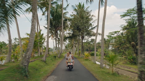 travel-couple-riding-motorbike-on-tropical-island-happy-woman-celebrating-freedom-with-arms-raised-enjoying-vacation-road-trip-with-boyfriend-on-motorcycle-ride-rear-view