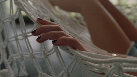 close-up-hand-of-woman-in-hammock-gently-moving-fingers-sleeping-comfortable-on-holiday-in-vacation-resort-swaying-peacefully-on-lazy-summer-day