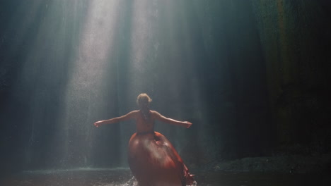 happy-woman-dancing-in-waterfall-cave-splashing-water-wearing-beautiful-dress-enjoying-nature-dance-feeling-spiritual-freedom-4k