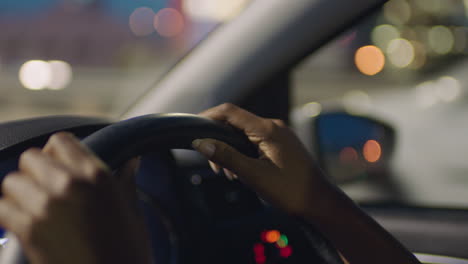 Mujer-Conduciendo-Un-Automóvil-Con-Las-Manos-En-El-Volante-En-La-Ciudad-Por-La-Noche-Viajando-Por-La-Carretera-Hacia-El-Destino