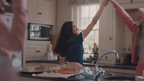 happy-group-of-teenage-girls-dancing-in-kitchen-eating-pizza-having-fun-celebrating-together-enjoying-hanging-out-together-on-party-weekend