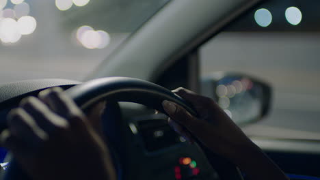woman-driving-car-with-hands-on-steering-wheel-in-city-at-night-travelling-on-the-road-to-destination