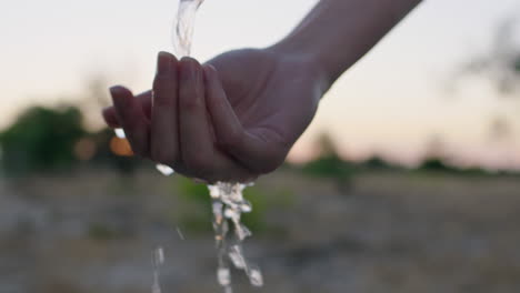 close-up-woman-washing-hand-under-tap-with-fresh-water-on-rural-farmland-at-sunrise