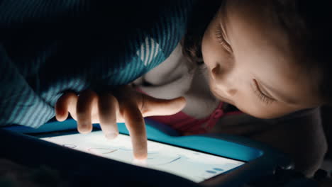 Süßes-Kleines-Mädchen,-Das-Einen-Digitalen-Tablet-Computer-Unter-Einer-Decke-Benutzt-Und-Es-Genießt,-Auf-Der-Touchscreen-Technologie-Zu-Zeichnen,-Spiele-Zu-Spielen-Und-Spaß-Vor-Dem-Schlafengehen-Zu-Haben