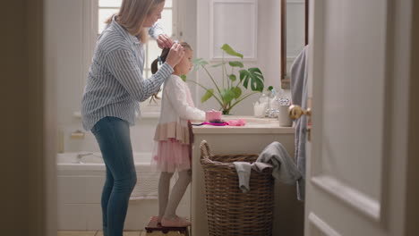 happy-mother-brushing-daughters-hair-in-bathroom-cute-little-girl-getting-ready-in-morning-loving-mom-enjoying-parenthood-caring-for-child