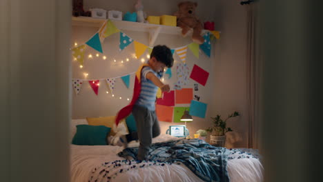 happy-little-boy-jumping-on-bed-wearing-costume-playing-game-enjoying-playful-imagination-in-colorful-bedroom-at-home