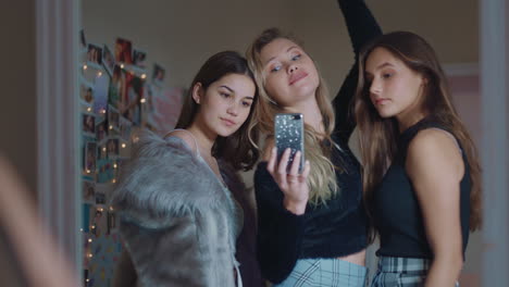 happy-girl-friends-taking-selfie-photos-using-smartphone-posing-in-mirror-sharing-stylish-fashion-on-social-media-enjoying-weekend-at-home-hanging-out-together