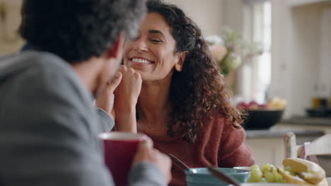 beautiful-happy-woman-chatting-to-husband-at-home-enjoying-conversation-holding-hands-in-kitchen-at-breakfast